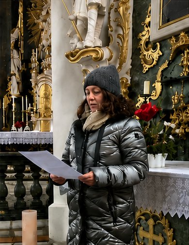 Eine Frau liest in einer reich geschmückten Kirche vor.
