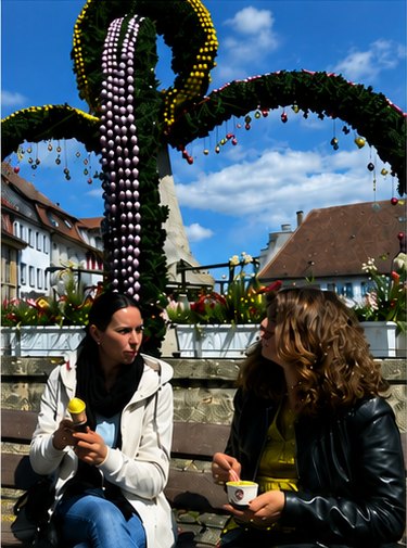 Zwei Frauen im Gespräch auf einem öffentlichen Fest.